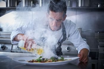 Chef working in kitchen with smoke and oil at restaurant
