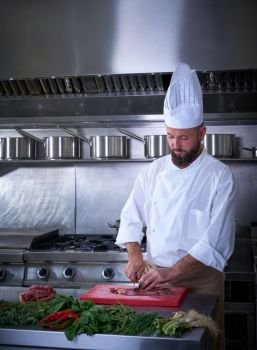 Chef cutting meat in restaurant kitchen of stainless steel