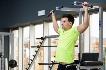 Young fit man wearing sportswear training at the gym. Healthy lifestyle and fitness concept.