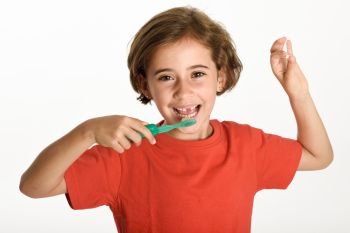 Happy little girl showing her first fallen tooth. Smiling little woman with a incisor in her hand brushing her teeth with a toothbrush isolates on white background. Studio shot.