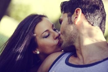 Attractive young couple kissing in a beautiful park