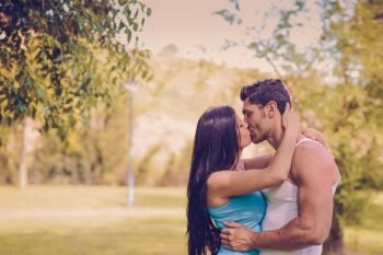 Attractive young couple kissing in a beautiful park