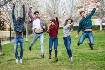 Group of multi-ethnic young people jumping together outdoors