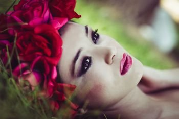 Close-up portrait of young beautiful japanese woman with pink and red flowers, model is an asian beauty 