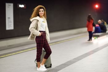 Beautiful young arabic female tourist waiting her train in a subway station. Arab girl in casual clothes.