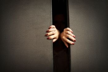 Female hands try to stop doors of the closed lift. The lift is closed