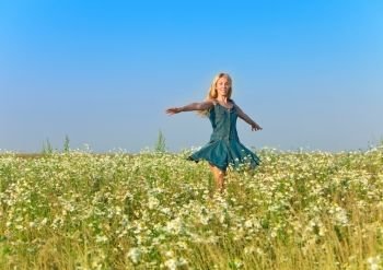 The happy young woman  in the field  of camomiles