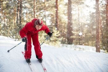A little boy in red clothes is skiing in a pine forest. skiing in the forest