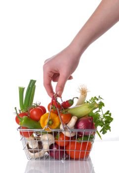 Raw vegetables and hand  in basket isolated on white