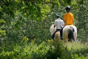 Riding Instructor and teenage boy in forest. Riding Instructor and teenage boy