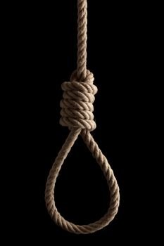 Rope noose with hangman’s knot hanging in front of  black background.