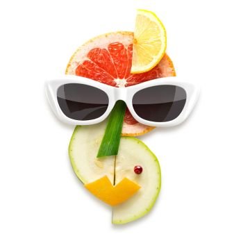Quirky food concept of cubist style female face in sunglasses made of fruits and vegetables, isolated on white.