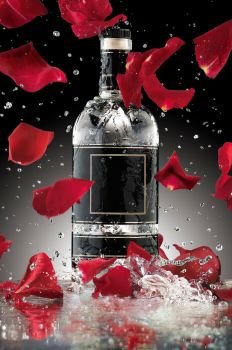 A photo of luxury alcohol bottle with falling rose leaves.