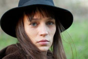 Sad woman with black hat in the countryside