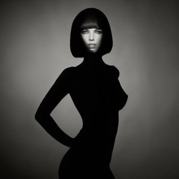 Black and white concept fashion photo of nude elegant woman wearing shadow. Brunette bob hairstyle. Fashion, Health and beauty