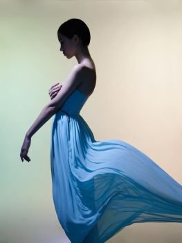 Fashion studio portrait of beautiful woman in azure flowing dress on colorful background. Asian beauty.