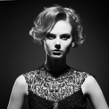 Studio fashion photo of beautiful young lady on black background. Classic studio portrait. Elegant hairstyle