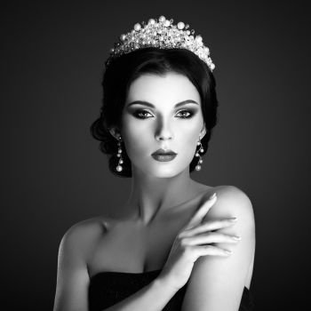 Fashion Portrait of Beautiful Woman with Tiara on head. Elegant Hairstyle. Perfect Make-Up and Jewelry. Red Lips. Black and White photo