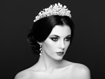 Fashion Portrait of Beautiful Woman with Tiara on head. Elegant Hairstyle. Perfect Make-Up and Jewelry. Red Lips. Black and White photo