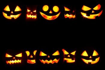 Halloween Pumpkins on black. Many Halloween Pumpkin glowing faces in a row isolated on black background