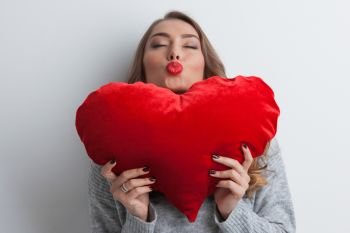Woman with pillow heart. Beautiful woman with red pillow heart, valentine’s day concept