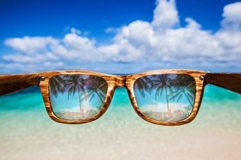 Sea view through sunglasses. View at tropical resort beach and sea through sunglasses