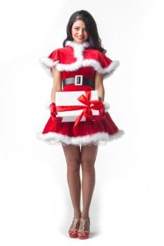 Woman in santa dress with gift. Beautiful young woman in Santa dress celebrating Christmas holding gift box