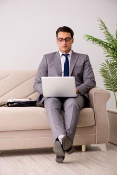 Businessman with laptop notebook sitting in sofa