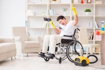 Disabled man with vacuum cleaner at home