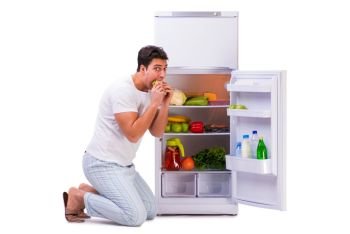 Man next to fridge full of food. The man next to fridge full of food