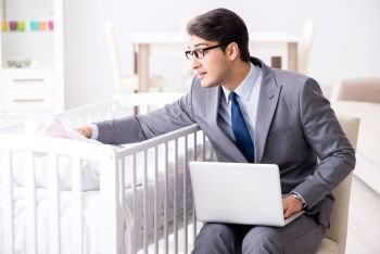 Young businessman trying to work from home caring after newborn baby. Young businessman trying to work from home caring after newborn 