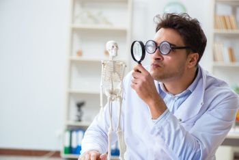 Crazy doctor studying human skeleton