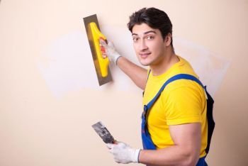 Young contractor employee applying plaster on wall