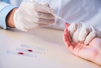 Doctor taking blood samples from finger