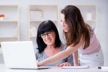 Daughter explaining to mom how to use computer