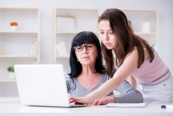 Daughter explaining to mom how to use computer