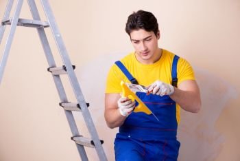 Young contractor employee applying plaster on wall