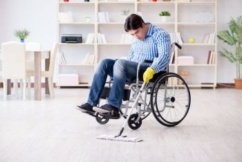 The disabled man on wheelchair cleaning home. Disabled man on wheelchair cleaning home
