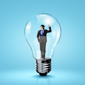 I have idea. Image of young businessman in light bulb. New idea and inspiration