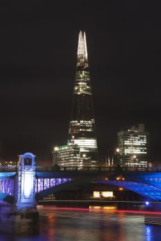 England, London, The Shard. The Shard in London at night looming over Blackfriars Bridge.. Landscape image of the London skyline at night looking along the River Thames
