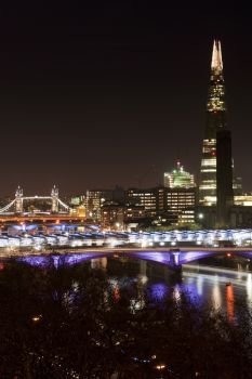 England, London, The Shard. The Shard in London towers over various bridges and tall buildings.. Landscape image of the London skyline at night looking along the River Thames