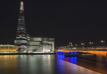 England, London, London Bridge. The Shard and London Bridge in London at night.. Stunning London City skyline landscape at night with glowing city lights and iconic landmark buldings and locations