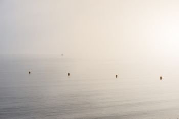 Minimalist fine art image of buoys at sea during foggy morning. Fine art minimalist image of buoys at sea during foggy morning