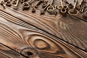 Various metal keys over wooden background