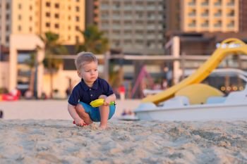 Two year old toddler playing on beach. Two year old toddler boy playing with beach toys on beach 
