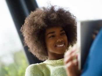 Young african american woman at home relaxing in her luxury lliving room reading a digital tablet  surf internet and work