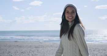 Portrait Of A Young Woman In Autumn Clothes Smiling On The Beach