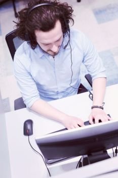 top view of a young smiling male call centre operator doing his job with a headset