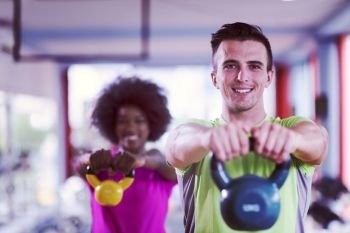 healthy couple  workout with weights lifting  dumbbels at  crossfit gym african  american woman with afro hairstyle. couple  workout with weights at  crossfit gym