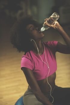 young afro american woman in gym on pilates workout break teaking breath and fresh drinking  water. young afro american woman in gym have pilates workout break